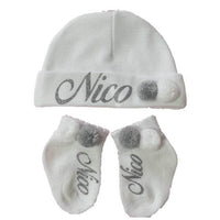 Personalisierte Mütze und Söckchen Set mit weiß/grau Bommel | Weiß - Minas Baby Paradies